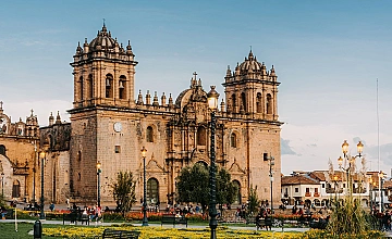 Catedral del Cusco en la Plaza de Armas, fachada colonial iluminada con jardines y cielo al atardecer