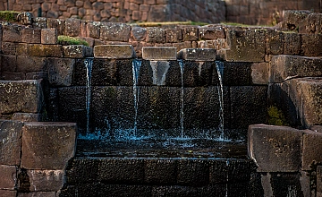 Fuentes escalonadas de Tipón en Cusco con agua fluyendo, arquitectura e hidráulica inca