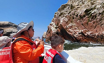 Paseo en lancha por Paracas: viajeros observando formaciones rocosas en el mar